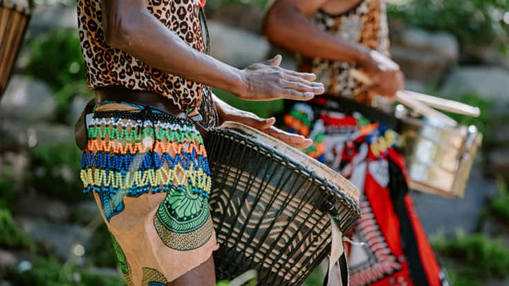 Experience West African griots play traditional djembe drums on an Oceania Cruises shore excursion.